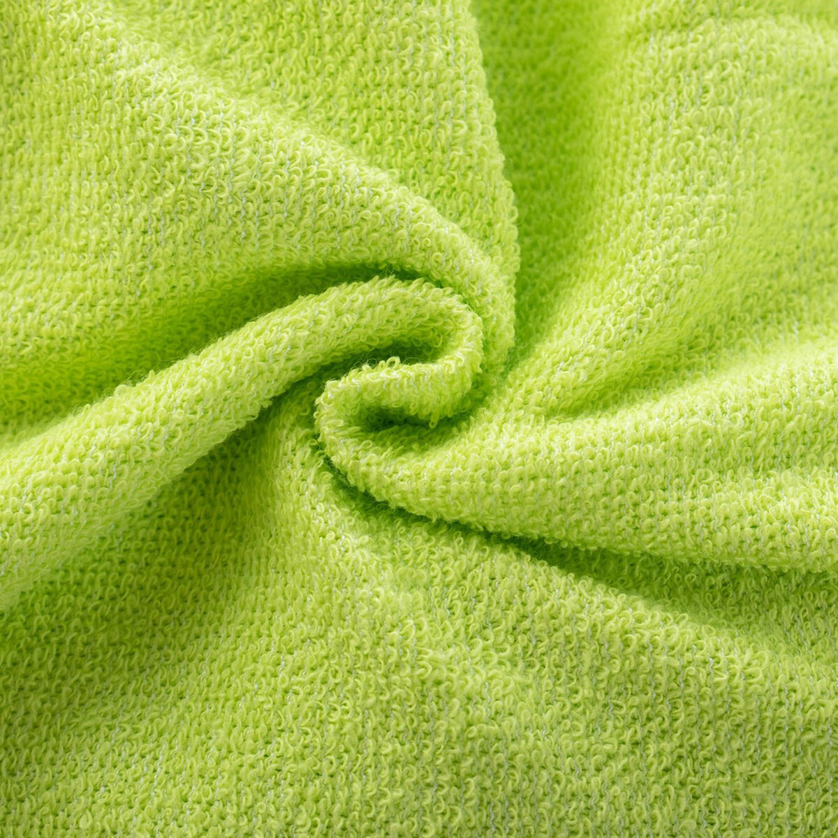 Zbliżenie na jasnozielony materiał frotte z widoczną teksturą i fałdami.