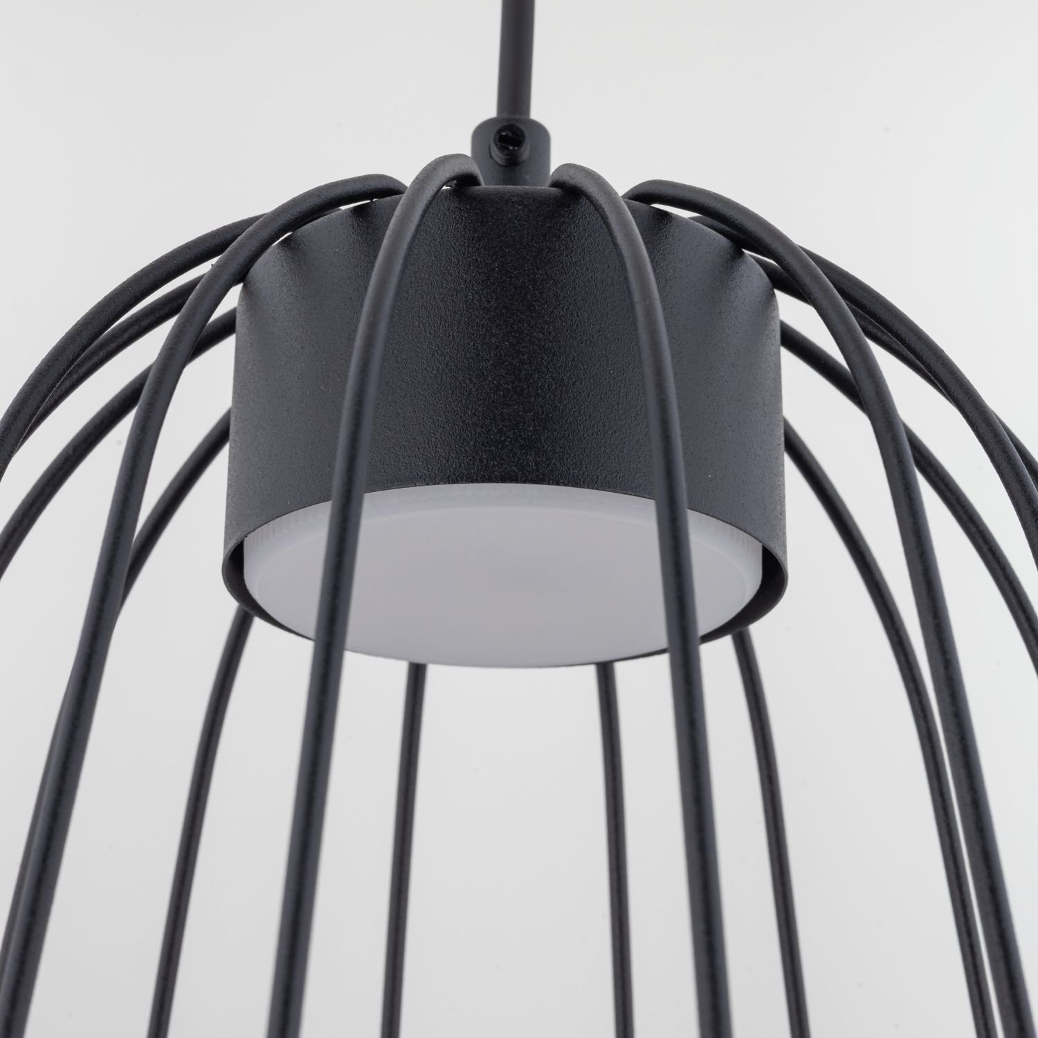 Czarna lampa wisząca z metalowymi prętami tworzącymi klosz wokół centralnego źródła światła. Lampa ma nowoczesny i elegancki design.
