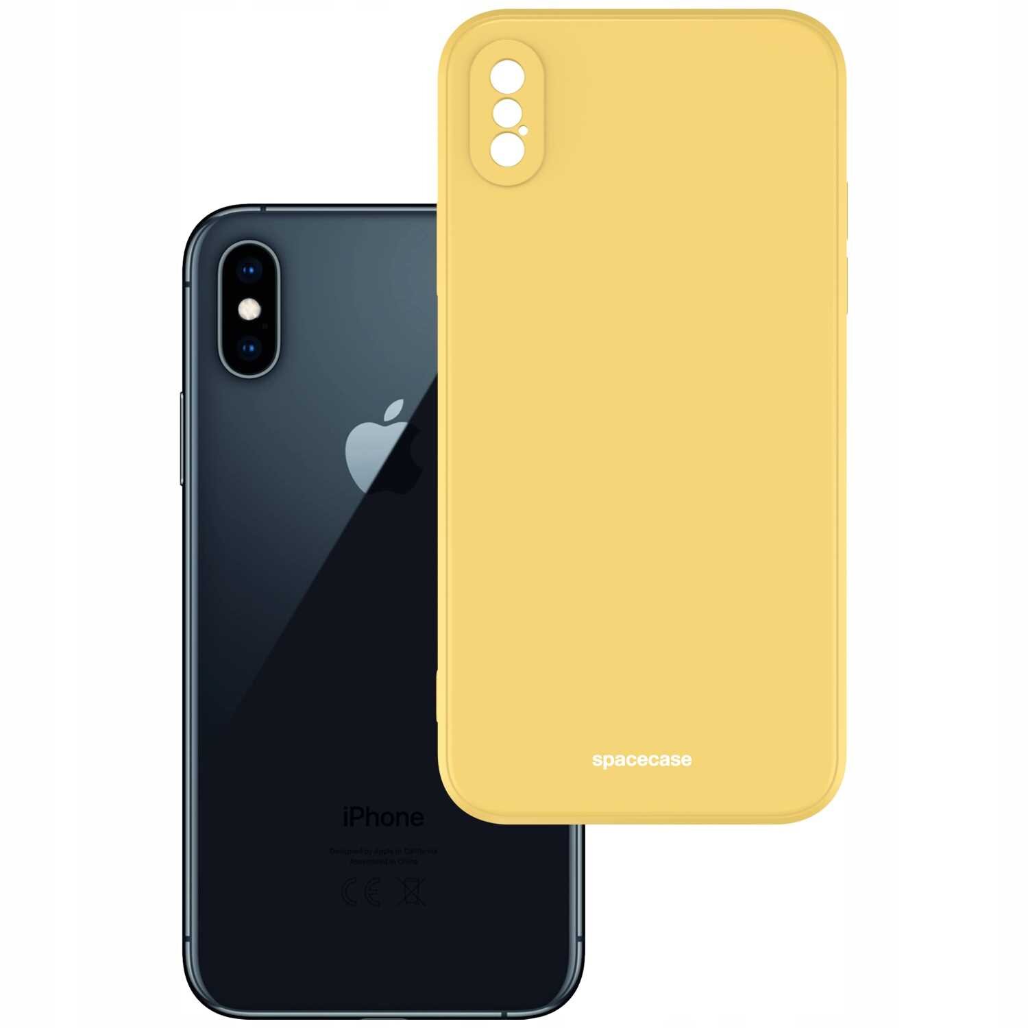 Na obrazie widoczne jest żółte silikonowe etui na telefon z napisem \'spacecase\'. Obok znajduje się czarny telefon z logo w kształcie jabłka.