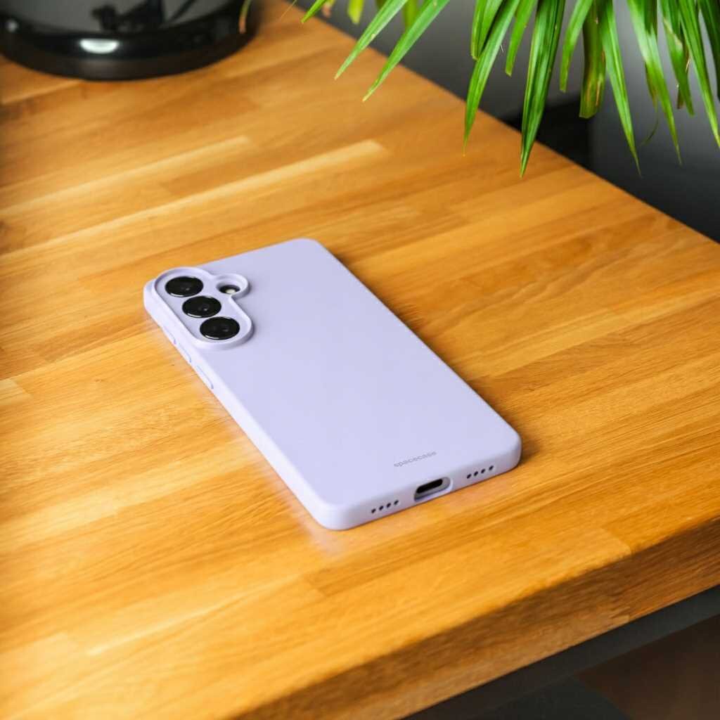 Fioletowe silikonowe etui na telefon leży na drewnianym blacie. Na etui widoczny jest napis \'SPACECASE\'.