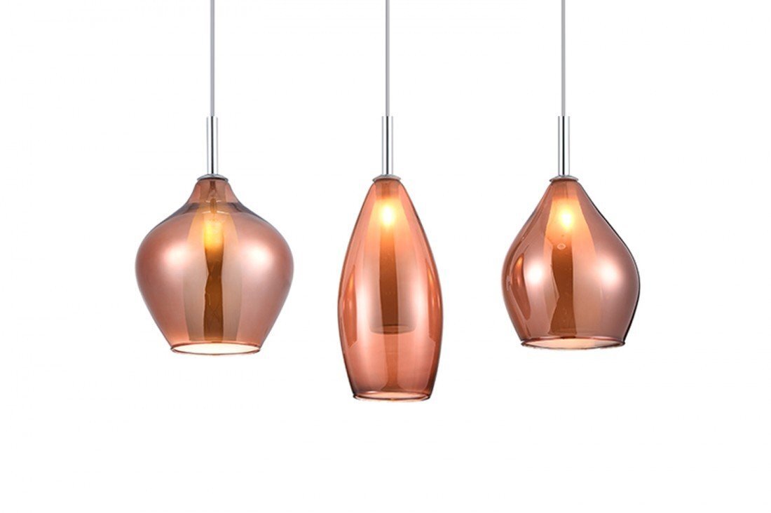 Trzy wiszące lampy o szklanych kloszach w kolorze bursztynowym, każda o innym kształcie. Lampy są zawieszone na cienkich, metalowych przewodach.