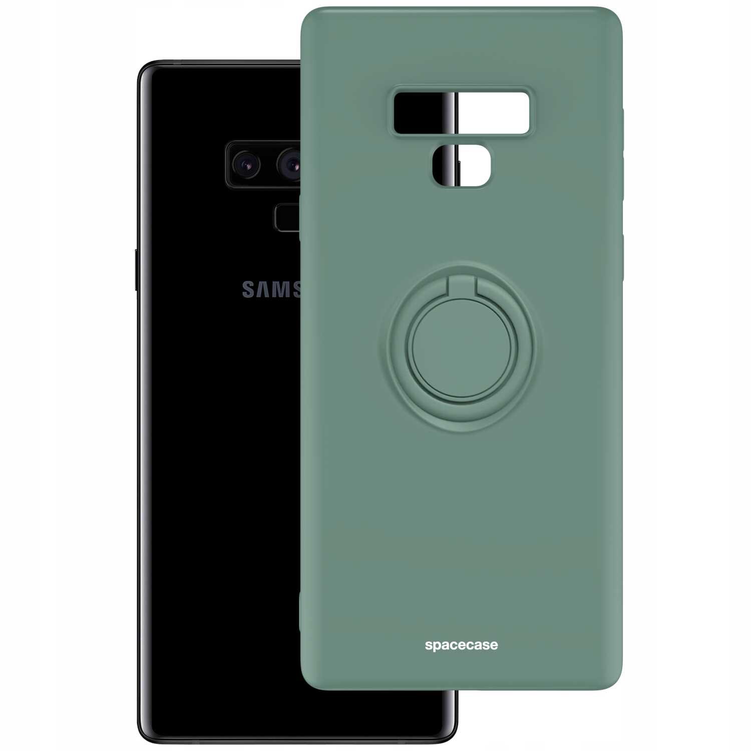 Zielone silikonowe etui z pierścieniem na tylnej stronie, obok czarnego telefonu z widocznym logo \'SAMSUNG\'. Na etui znajduje się napis \'spacecase\'.