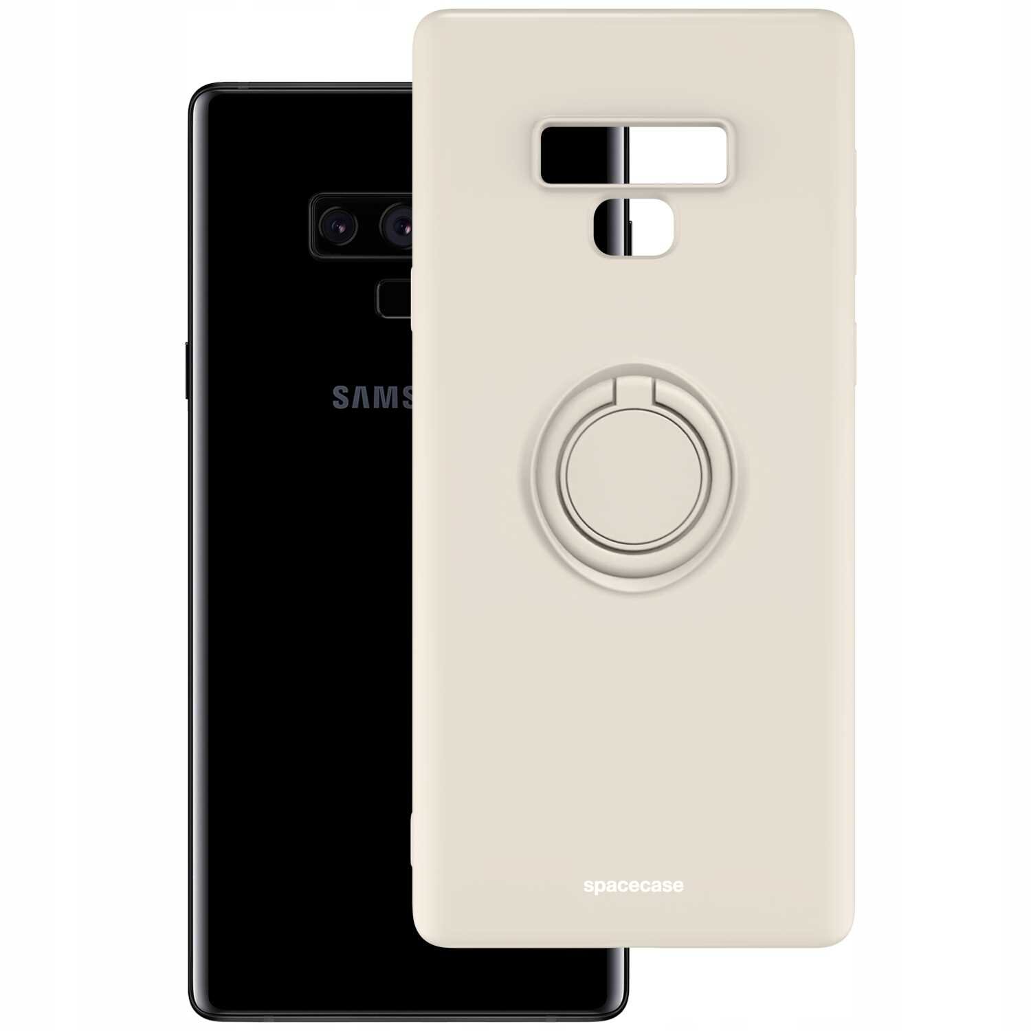Beżowe silikonowe etui z pierścieniem na tylnej stronie, obok czarnego telefonu z widocznym logo \'SAMSUNG\'. Na etui znajduje się napis \'spacecase\'.