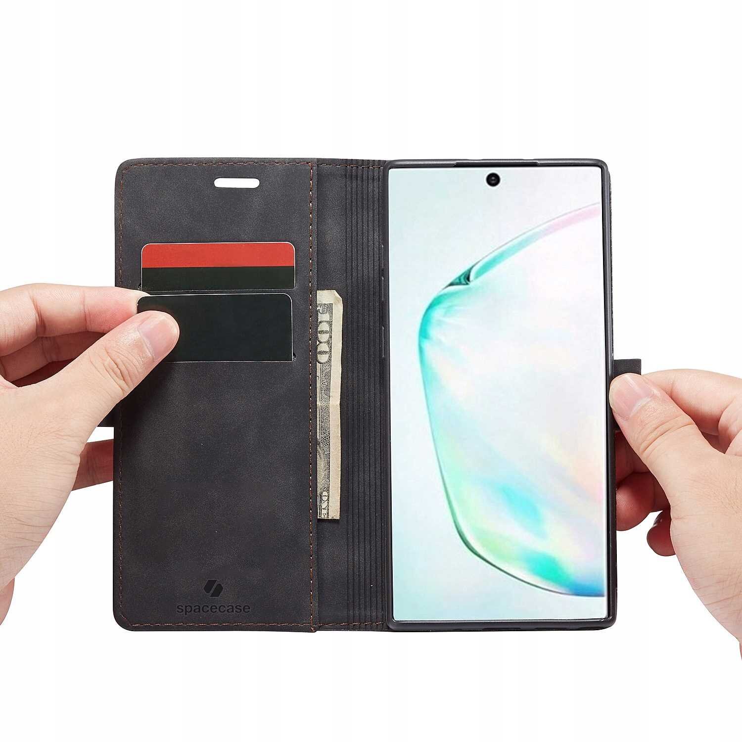 Etui z klapką w kolorze czarnym, otwarte, z miejscem na karty i banknoty, obok smartfon z wyświetlaczem. Na etui widoczne jest logo \'spacecase\'.
