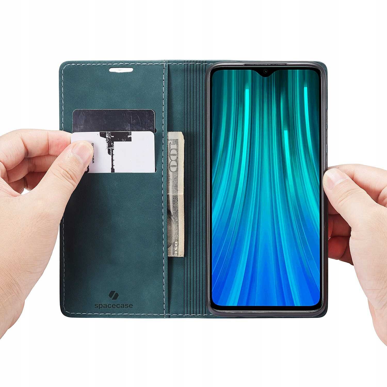 Etui z klapką w kolorze niebieskim, z miejscem na kartę i banknot, trzymające telefon z wyświetlaczem w odcieniach zieleni. Na etui widoczne jest logo \'spacecase\'.