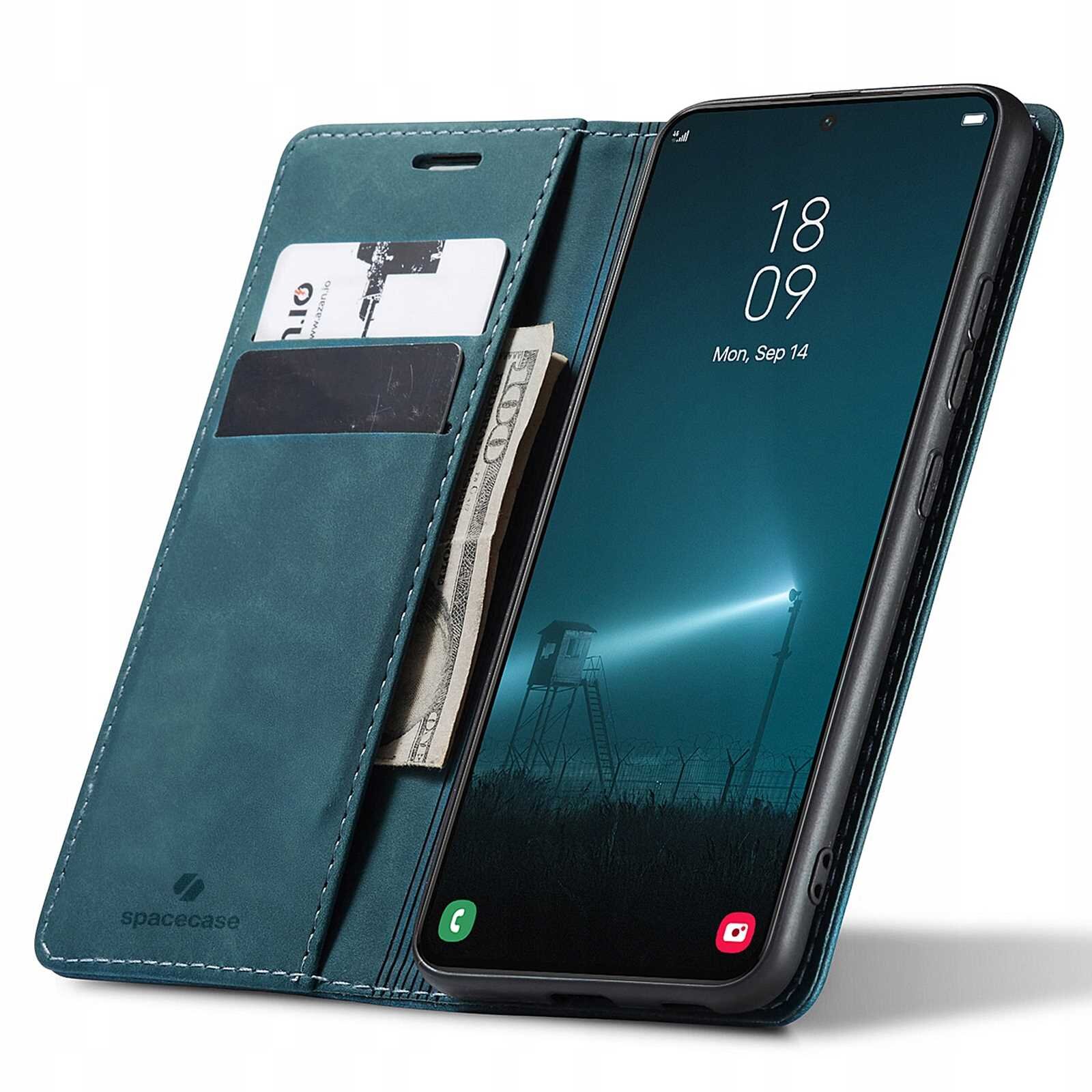 Etui z klapką w kolorze niebieskim z miejscem na karty i banknoty, obok smartfon z wyświetlaczem pokazującym godzinę 18:09 i datę Mon, Sep 14. Na etui widoczne jest logo \'spacecase\'.
