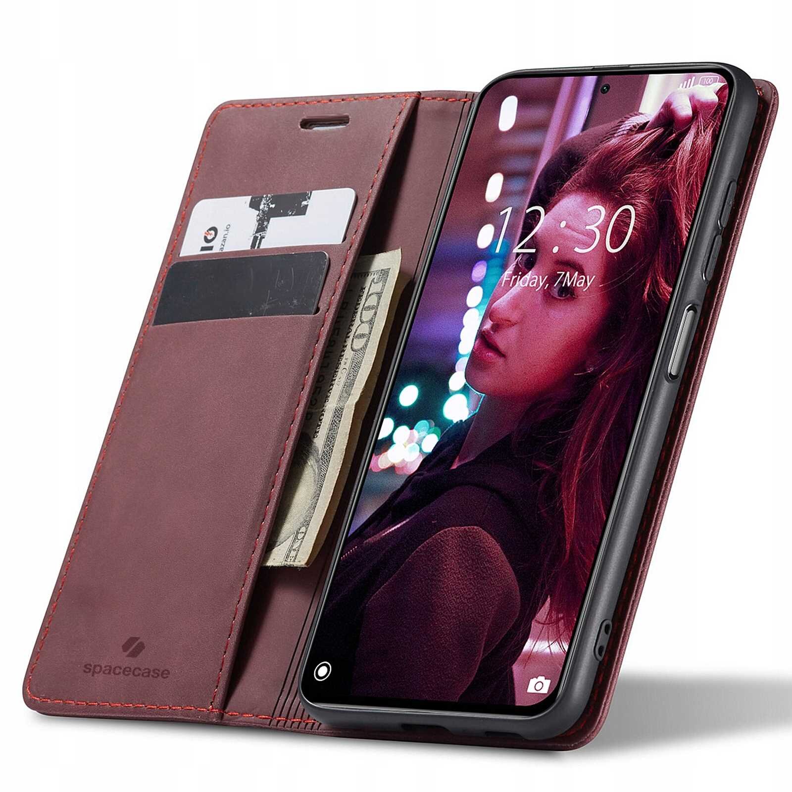 Czerwone etui z klapką na telefon, z miejscem na karty i banknoty, z logo \'spacecase\'. Telefon w etui wyświetla ekran z godziną 12:30 i datą Friday, 7 May.