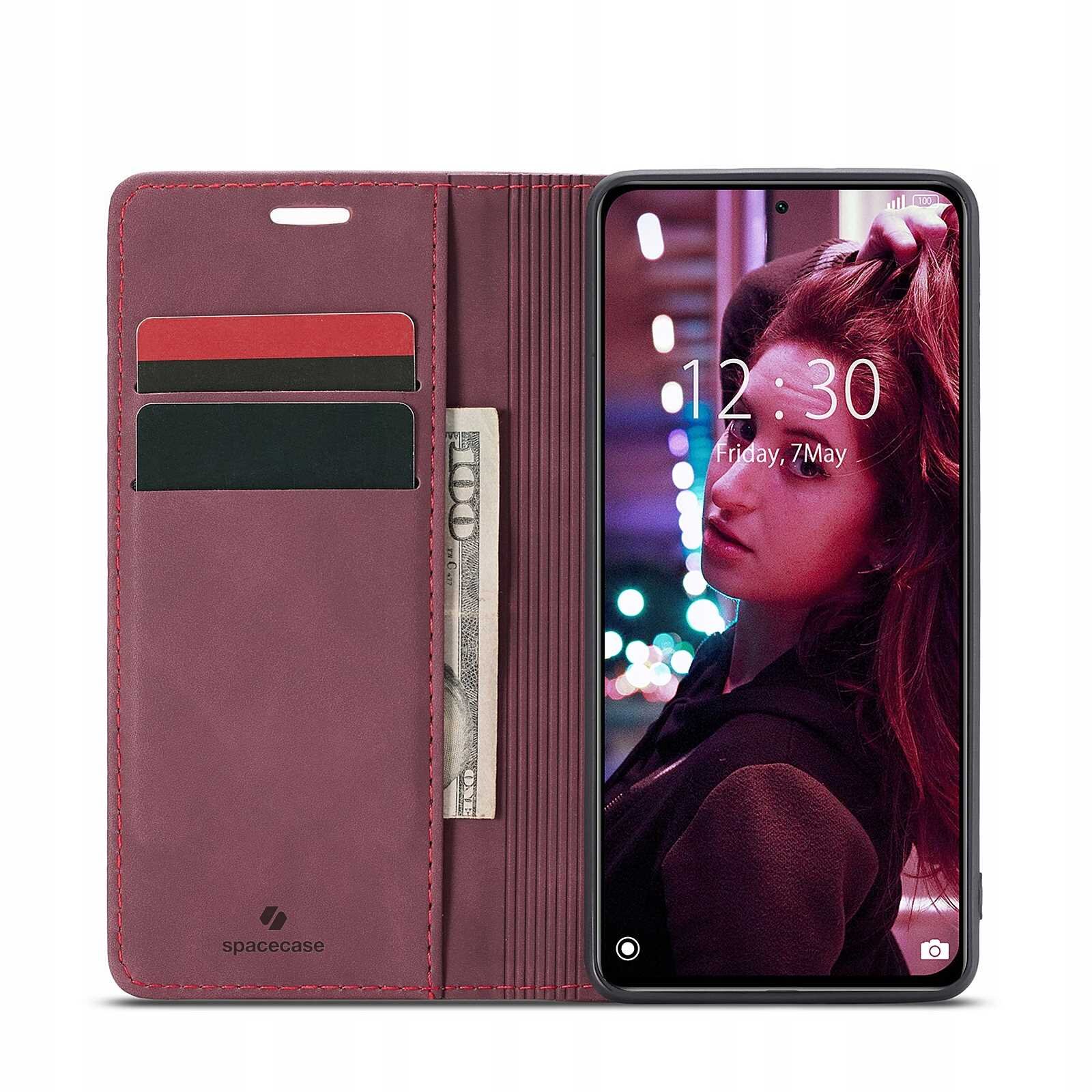 Etui z klapką w kolorze czerwonym z miejscem na karty i banknoty, obok smartfon z wyświetlaczem pokazującym godzinę 12:30 i datę Friday, 7 May. Na etui widoczne jest logo \'spacecase\'.