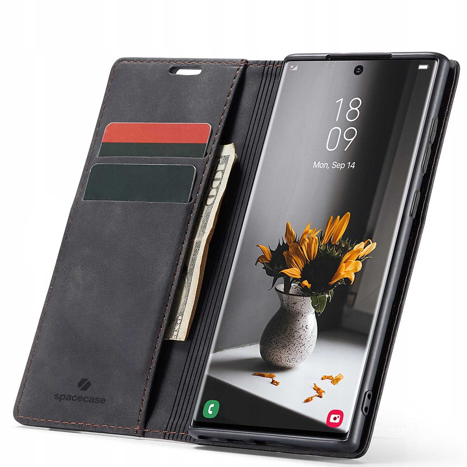 Czarne etui z klapką na telefon, z miejscem na karty i banknoty, obok telefonu z wyświetlaczem pokazującym godzinę 18:09 i datę Mon, Sep 14. Na ekranie telefonu widoczny jest obrazek wazonu z kwiatami, a na etui znajduje się logo \'spacecase\'.