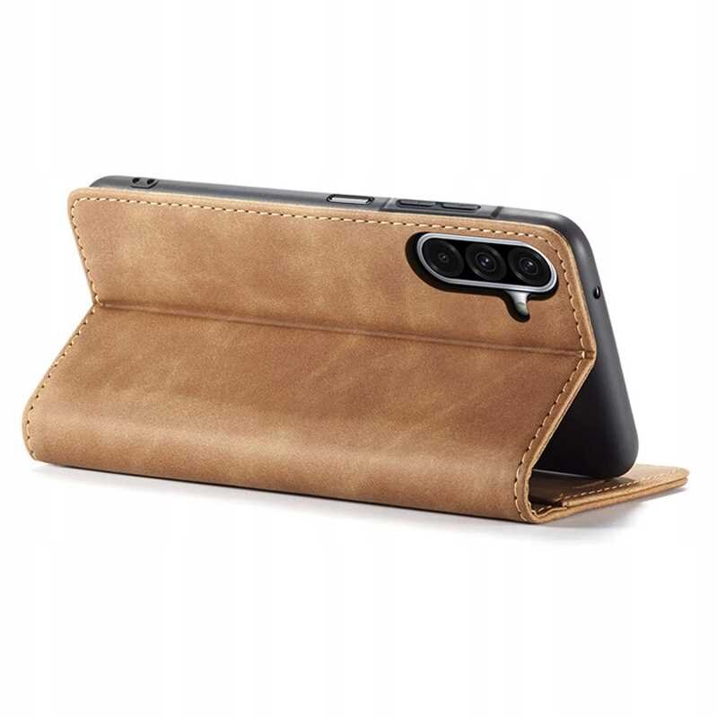 Brązowe etui z klapką ustawione w pozycji stojącej, z widocznymi trzema otworami na aparat telefonu. Etui ma gładką powierzchnię i przeszycia na krawędziach.