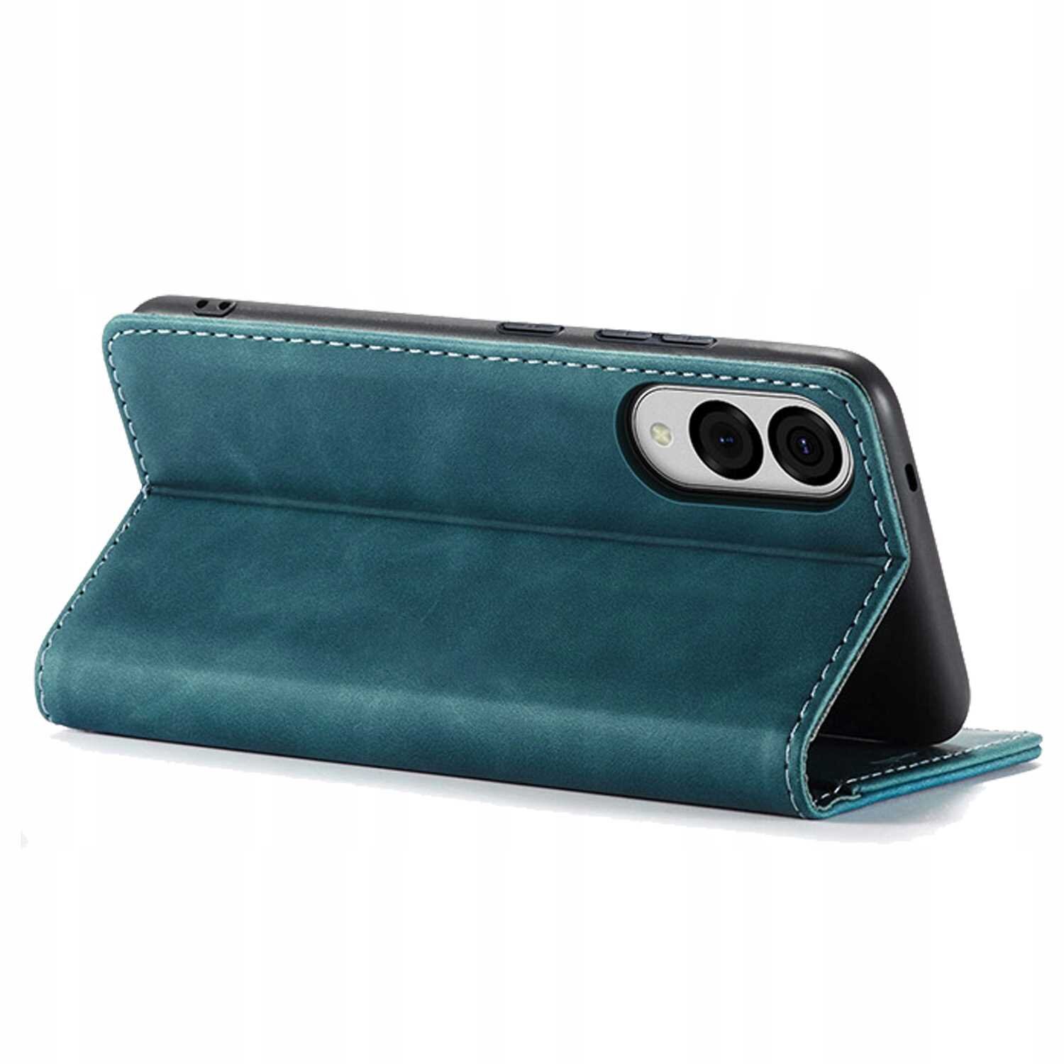 Niebieskie etui z klapką ustawione w pozycji stojącej, z widocznymi dwoma obiektywami aparatu telefonu. Etui ma widoczne przeszycia na krawędziach.