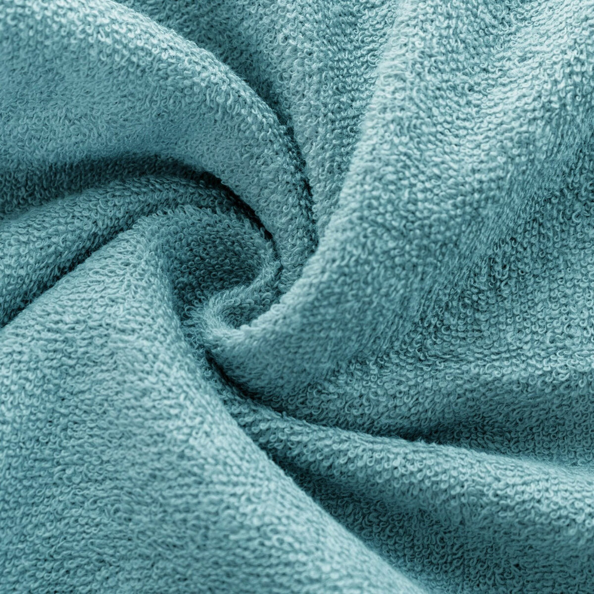 Zbliżenie na materiał frotte w kolorze turkusowym, ułożony w spiralny wzór. Widoczna jest tekstura tkaniny z drobnymi pętelkami.