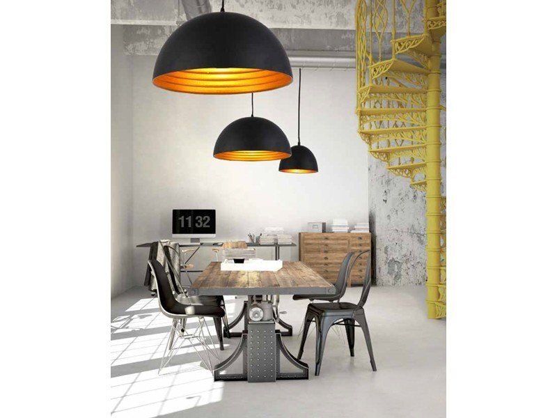 Wnętrze z drewnianym stołem otoczonym metalowymi krzesłami, nad którym wiszą trzy czarne lampy z pomarańczowym wnętrzem. W tle widoczna jest żółta, spiralna klatka schodowa oraz zegar pokazujący godzinę 11:32.