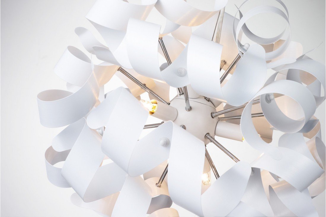 Lampa wisząca o nowoczesnym designie z białymi, zakrzywionymi elementami przypominającymi wstążki, zamocowanymi na metalowych prętach. Wewnątrz widoczne są żarówki emitujące ciepłe światło.