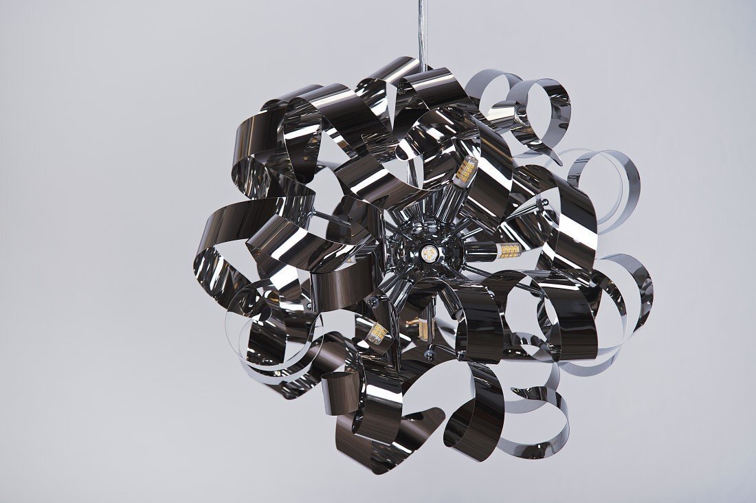 Lampa wisząca o nowoczesnym designie, składająca się z wielu metalowych, błyszczących taśm ułożonych w kulisty kształt. Wewnątrz widoczne są żarówki, a całość zawieszona jest na cienkim przewodzie.