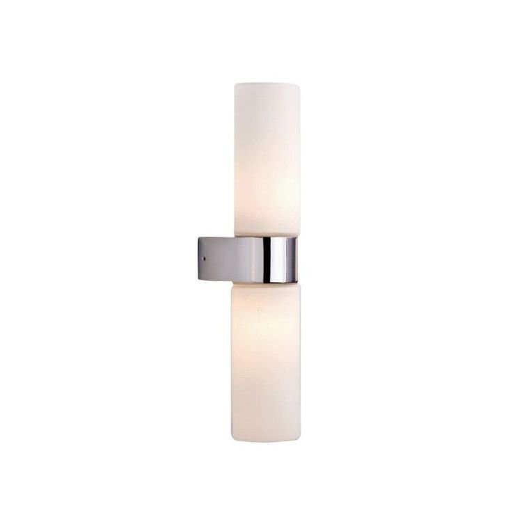 Na obrazie widoczna jest lampa ścienna z dwoma cylindrycznymi kloszami w kolorze białym, zamocowana na metalowym uchwycie. Klosze są umieszczone pionowo, a uchwyt ma srebrne wykończenie.