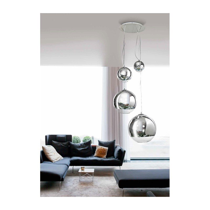 Nowoczesna lampa wisząca z trzema srebrnymi kulami zawieszonymi na różnych wysokościach. W tle widoczny jest elegancki salon z ciemną sofą i dużymi oknami.