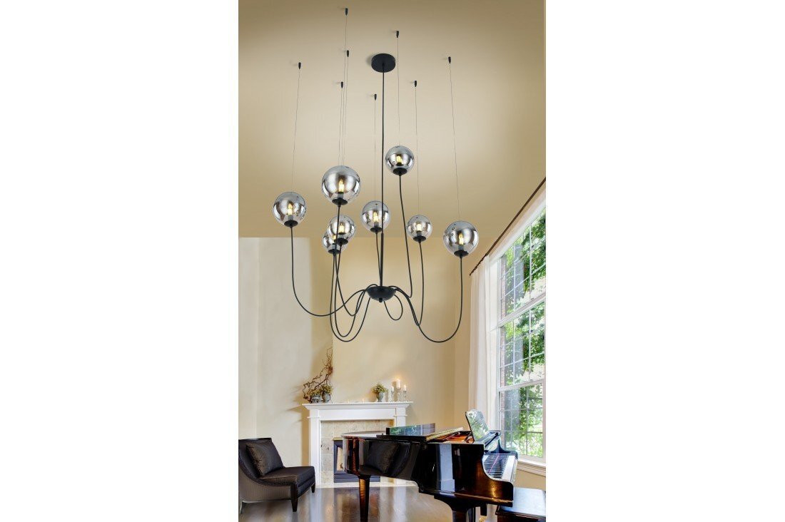 Na obrazie widoczna jest stylowa lampa wisząca z ośmioma źródłami światła, umieszczona w eleganckim wnętrzu z fortepianem i kominkiem. Lampa ma nowoczesny design z kulistymi kloszami i czarnymi ramionami.