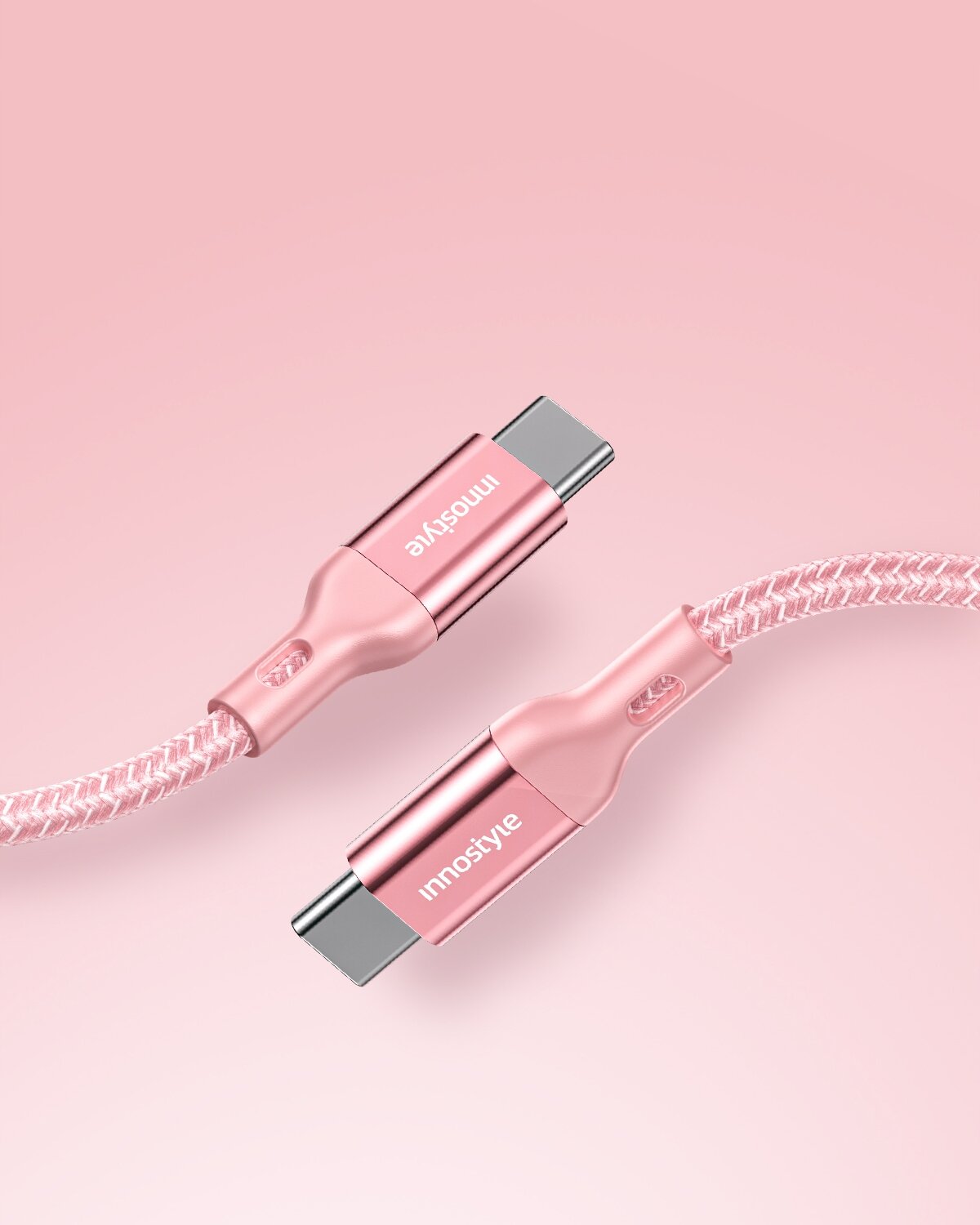 Różowy kabel USB-C z plecionym oplotem i metalowymi końcówkami, na których widnieje napis \'innostyle\'.