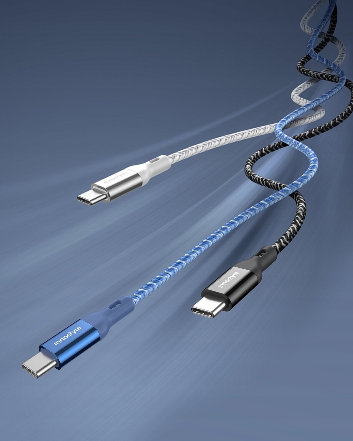 Trzy kable USB-C o różnych kolorach z widocznymi napisami \'innostyle\' na końcówkach, na niebieskim tle.
