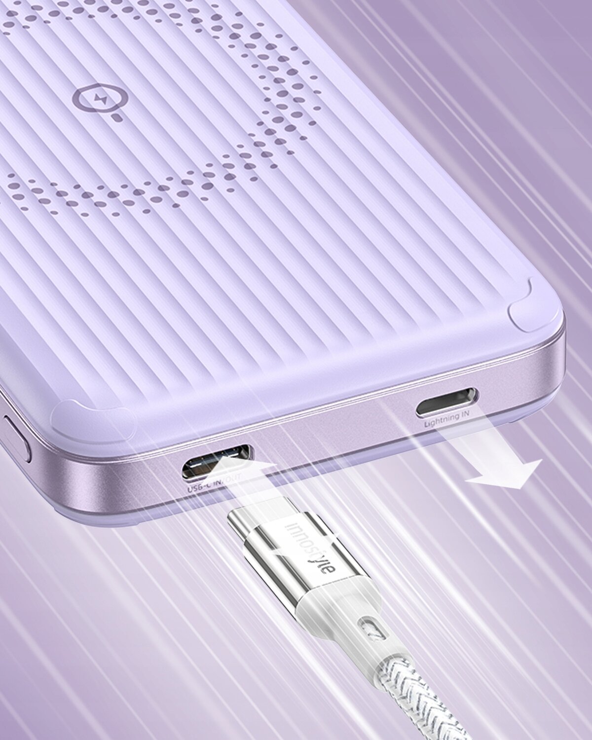 Fioletowy powerbank z widocznymi portami USB-C i Lightning oraz podłączonym kablem. Na powierzchni znajduje się okrągły wzór i logo producenta.