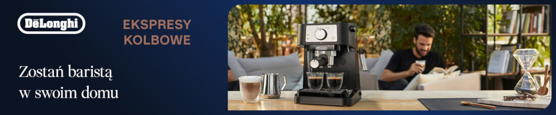 Reklama ekspresu kolbowego z logo DeLonghi i napisem \'Zostań baristą w swoim domu\'. Obok ekspresu znajdują się filiżanki z kawą i metalowy dzbanek, a w tle widać osobę siedzącą na kanapie.