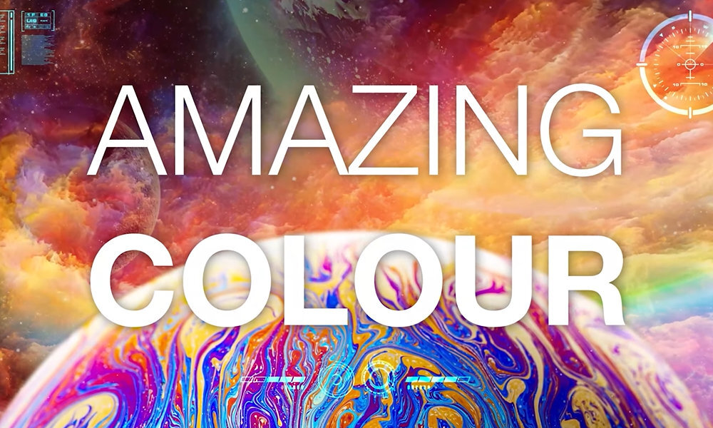 Obraz przedstawia kolorowe tło z napisem \'AMAZING COLOUR\'. W tle widoczne są abstrakcyjne wzory i intensywne kolory.