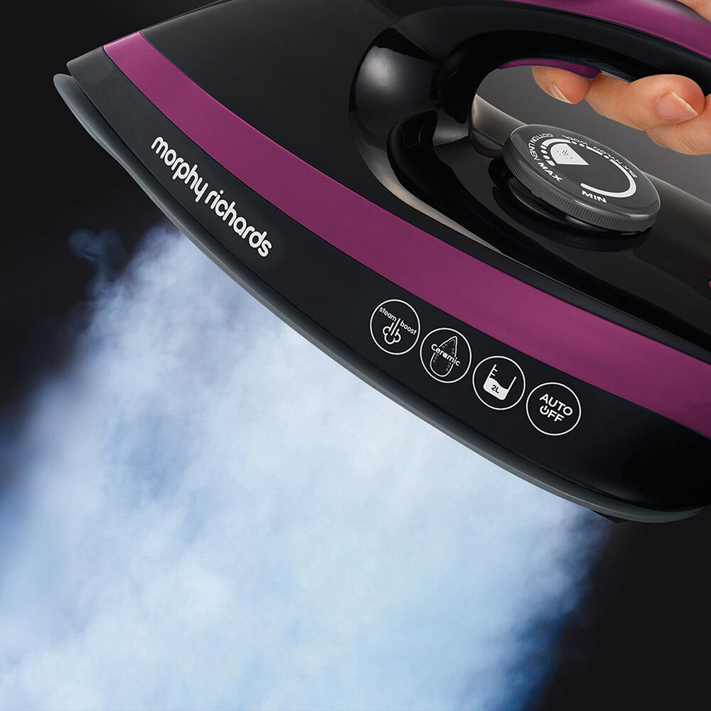 Zbliżenie na żelazko parowe z logo \'morphy richards\' i ikonami: steam boost, ceramic, 2L, AUTO OFF. Z urządzenia wydobywa się para.