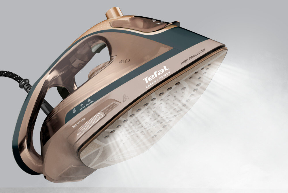 Żelazko w kolorze brązowym z widocznym logo \'Tefal Energy Power\' oraz napisem \'HIGH PRECISION\'. Z otworów w stopie żelazka wydobywa się para.