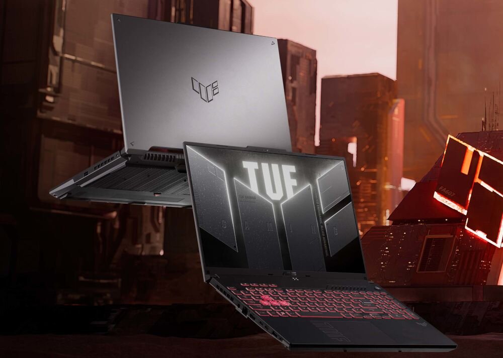 Dwa laptopy z serii TUF, jeden otwarty z podświetlaną klawiaturą i napisem \'TUF\' na ekranie, drugi zamknięty z logo TUF na obudowie. W tle widoczne są futurystyczne budynki.