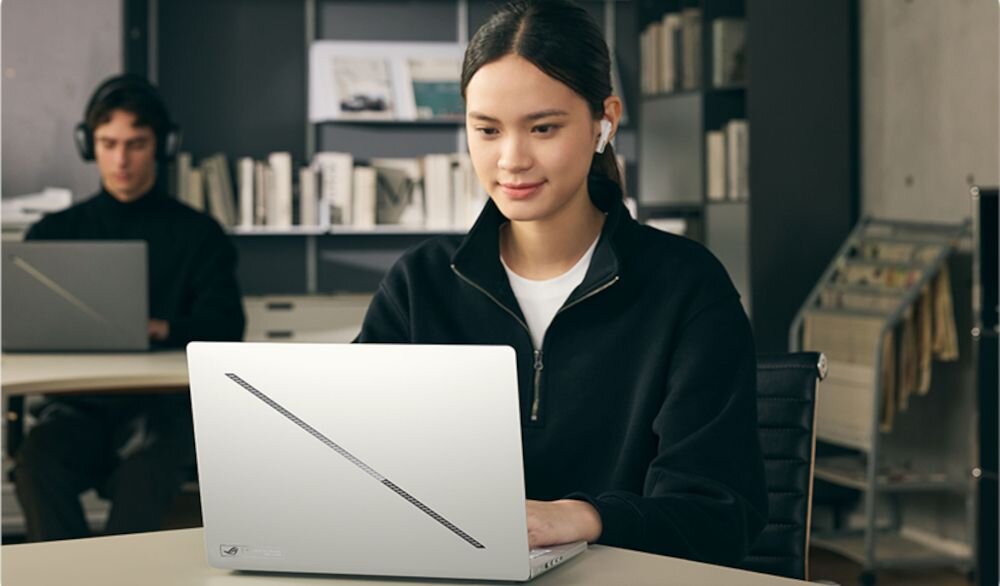 Osoba korzysta z laptopa ASUS ROG Zephyrus z Wi‑Fi podczas pracy w nowoczesnej przestrzeni co-workingowej przy biurku