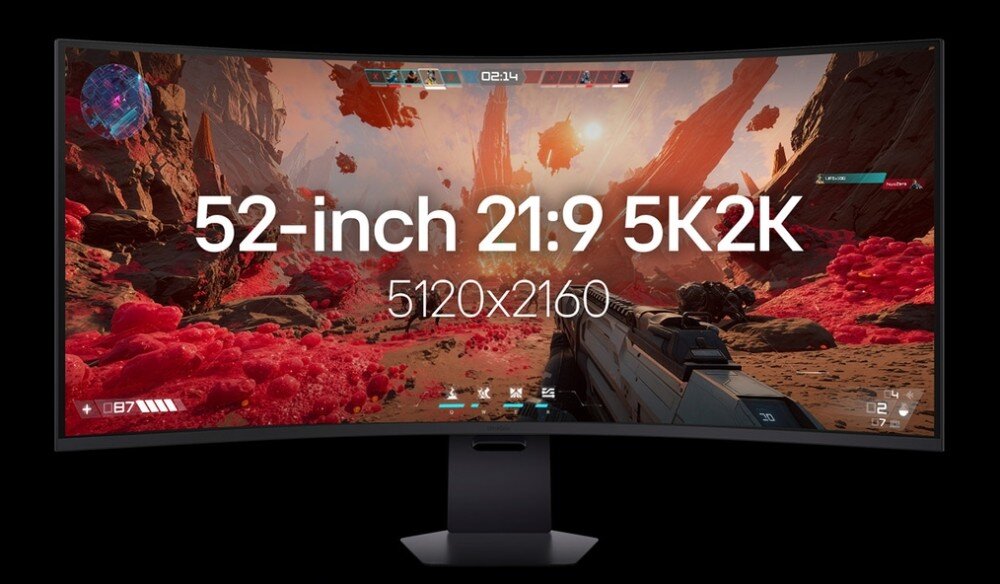 Monitor wyświetla kolorową scenę z gry wideo z krajobrazem pełnym czerwonych skał i nieba. Na ekranie widoczny jest tekst: \'52-inch 21:9 5K2K 5120x2160\'.