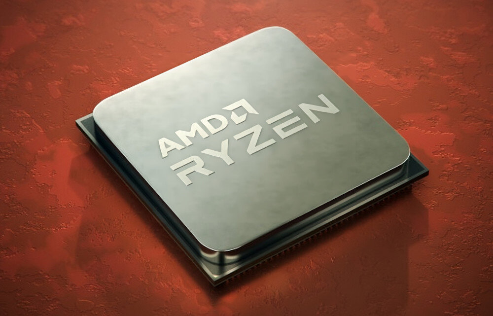 Na obrazie widoczny jest procesor z napisem \'AMD RYZEN\' na metalowej powierzchni, umieszczony na czerwonym tle.