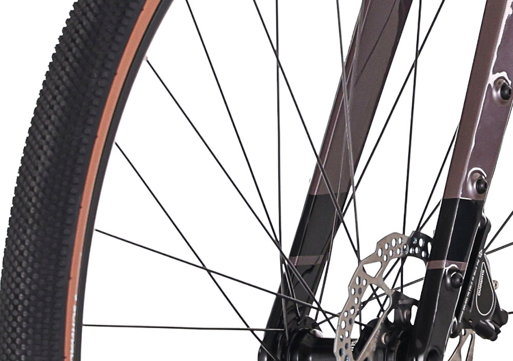 Rower gravel ROCK MACHINE Lukk CR 30 U21 28 cali Fioletowy zbliżenie na oponę białe tło rozmiar koła 28 cali łatwiej jest pokonać różne przeszkody opony marki SCHWALBE obręcze marki One J25D piasty SHIMANO regularne sprawdzanie ciśnienia powietrza wartość na bocznej części opony