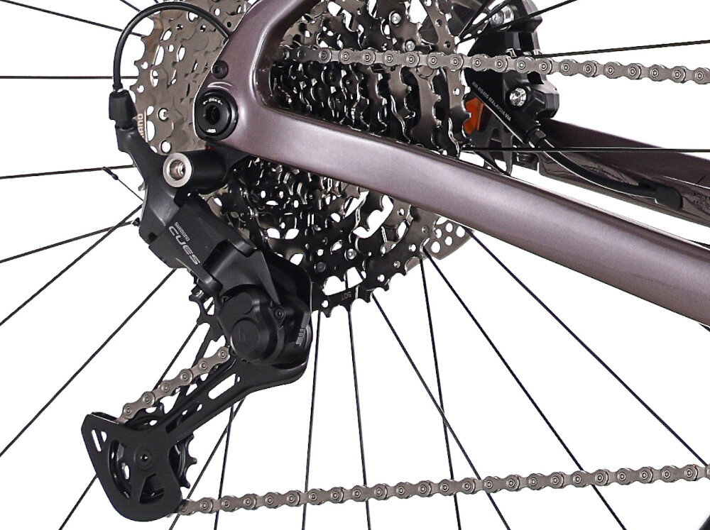 Rower gravel ROCK MACHINE Lukk CR 30 U21 28 cali Fioletowy zbliżenie na tylną przerzutkę białe tło przerzutki SHIAMNO 11 przełożeń duża wytrzymałość sprawne działanie zmiana biegów jest płynna i bezproblemowa Tylny napęd SHIMANO CUES komfortowa kadencja łatwiej zachować rytm jazdy