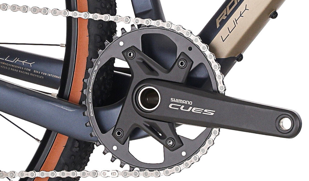 Rower gravel ROCK MACHINE Lukk CR 30 U20 28 cali Fioletowy zbliżenie na korbę białe tło wkład suportu SHIMANO typu BSA korba SHIMANO typu CUES typu FC-U6030,42T, 170 mm kaseta SHIMANO typu CS-LG400-11 o zakresie 11–50T odpowiednie przełożenie szeroki zakres kasety odpowiednio dobrane komponenty