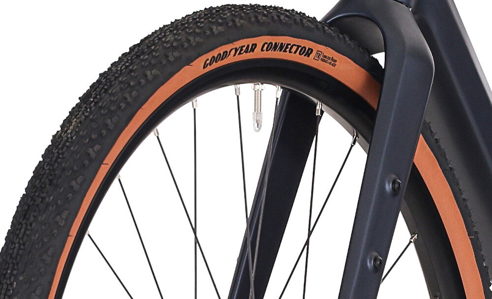 Rower gravel ROCK MACHINE Lukk CR 30 U21 28 cali Fioletowy zbliżenie na oponę białe tło rozmiar koła 28 cali łatwiej jest pokonać różne przeszkody opony marki Goodyear obręcze marki One J25D piasty SHIMANO regularne sprawdzanie ciśnienia powietrza wartość na bocznej części opony