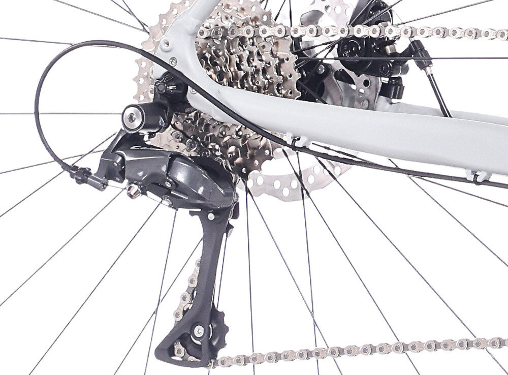 Rower gravel ROCK MACHINE Lukk 20 Flat Bar U22 28 cali Szary mat zbliżenie na tylną przerzutkę białe tło przerzutki SHIAMNO 16 przełożeń duża wytrzymałość sprawne działanie zmiana biegów jest płynna i bezproblemowa przednie i tylne przerzutki SHIMANO Claris komfortowa kadencja łatwiej zachować rytm jazdy