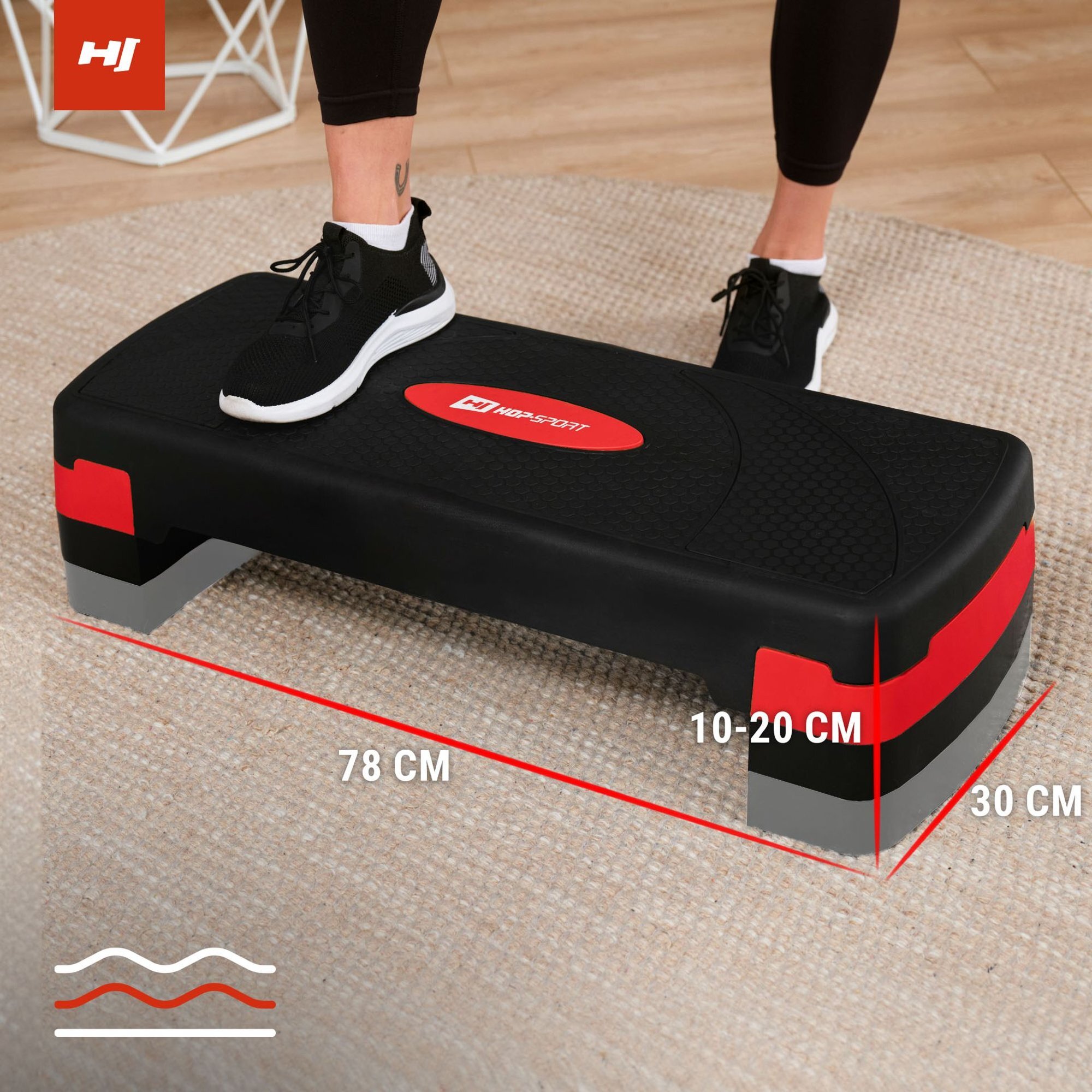 Czarno-czerwony step do ćwiczeń z logo \'HOP-SPORT\' na środku, z wymiarami 78 cm długości, 30 cm szerokości i regulowaną wysokością 10-20 cm. Na stepie stoi osoba w czarnych butach sportowych.