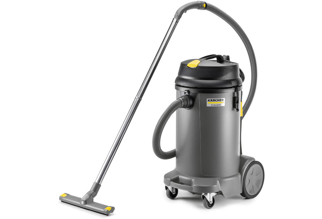 Na obrazie widoczny jest szary odkurzacz przemysłowy z dużymi kołami i długą rurą ssącą. Na urządzeniu znajduje się logo \'KARCHER Professional\'.