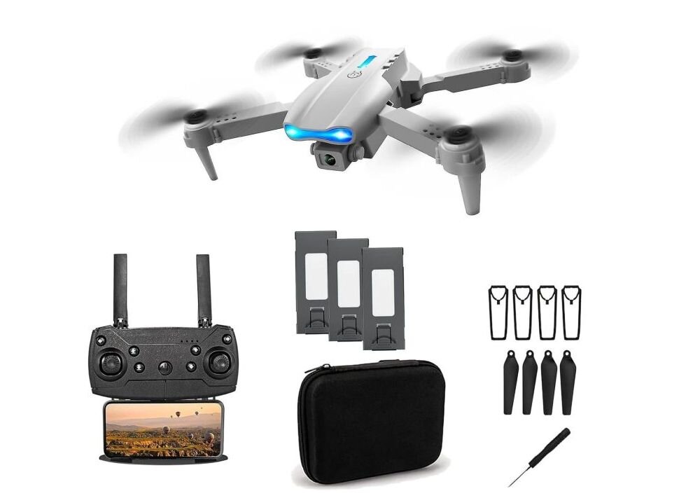 Na obrazie widoczny jest dron z czterema śmigłami, kontroler z ekranem, trzy baterie, etui, cztery zapasowe śmigła, cztery osłony na śmigła i mały śrubokręt. Dron ma szary kolor z niebieskim światłem na przodzie.