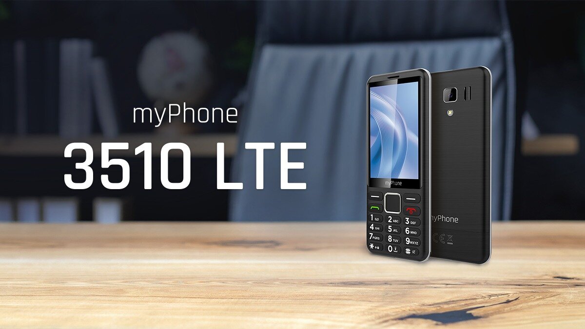 Na drewnianym stole znajduje się czarny telefon myPhone 3510 LTE z klawiaturą numeryczną. Obok telefonu widoczny jest napis \'myPhone 3510 LTE\'.