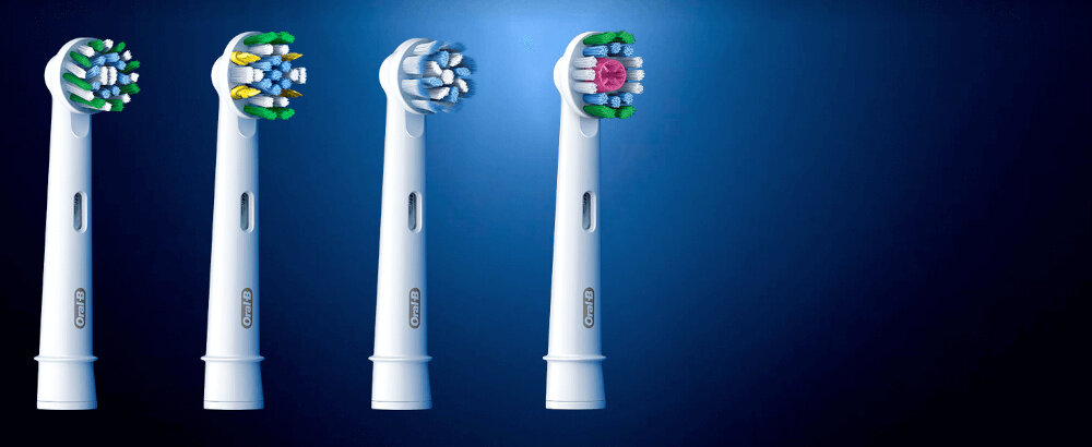 Na obrazie widoczne są cztery białe końcówki szczoteczek do zębów z różnymi układami włosia. Każda końcówka ma logo \'Oral-B\'.