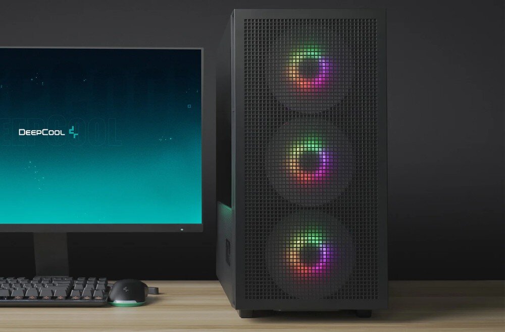 Na obrazie widoczna jest czarna obudowa komputerowa z trzema wentylatorami RGB na przednim panelu. Obok znajduje się monitor z logo \'DeepCool\' na ekranie oraz klawiatura i mysz na biurku.