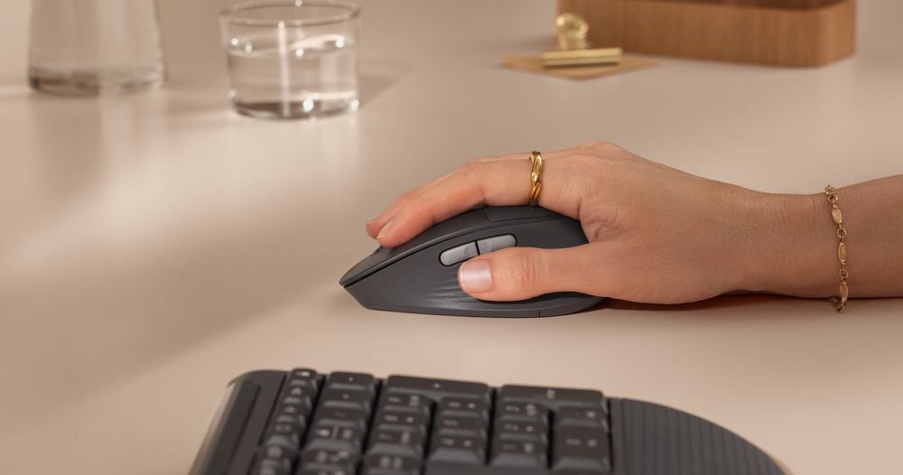 LOGITECH Signature Comfort Plus MK880 Mysz bezprzewodowa miękką podpórkę pod dłoń profilowany kształt, antypoślizgowe gumowe uchwyty boczne oraz specjalnie wyprofilowane miejsce na kciuk - zbliżenie na rękę kobiety trzymającej myszkę