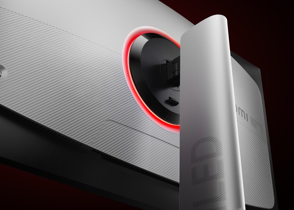 Monitor XIAOMI G Pro 27Qi Zbliżenie na tył monitora z czarnym kołem podświetlonym na czerwono i białym stojakiem. Koło ma szeroki, czarny brzeg. Stojak ma jasnoszary, matowy odcień z napisami 'MINI LED', konstrukcja, ramka, podstawa