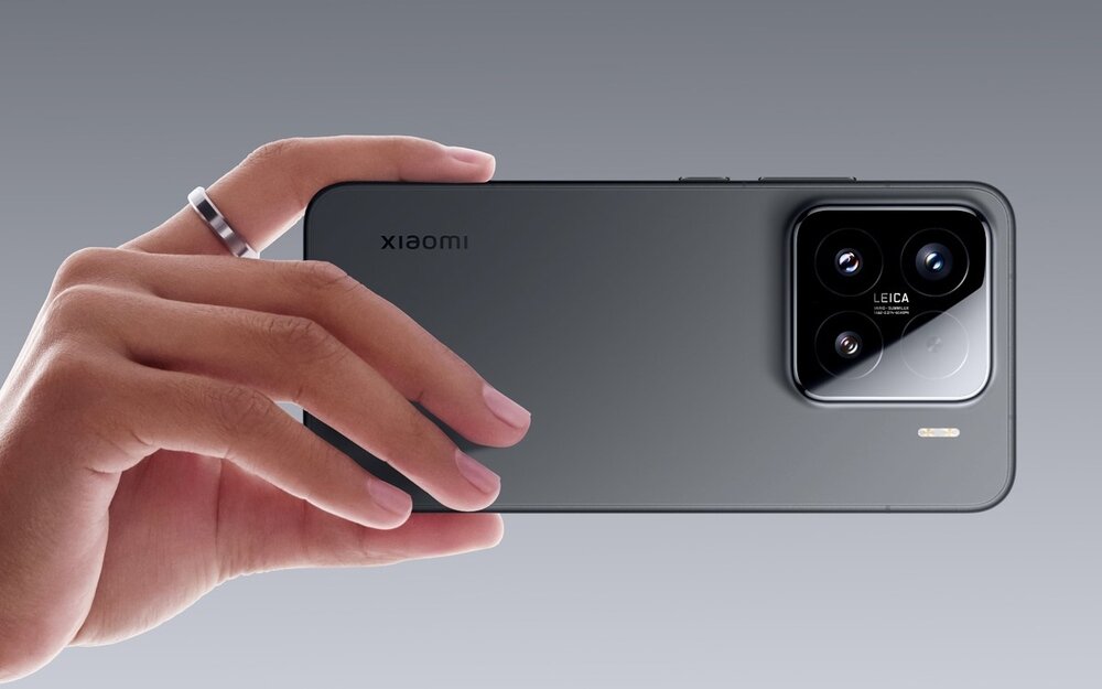 Osoba trzyma czarny smartfon z widocznym logo \'xiaomi\' i modułem aparatu z trzema obiektywami oraz napisem \'LEICA\'.
