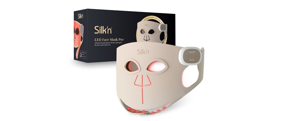 Na obrazie znajduje się beżowa maska LED do twarzy z wycięciami na oczy i usta oraz pudełko z napisem \'Silk\'n LED Face Mask Pro\'.
