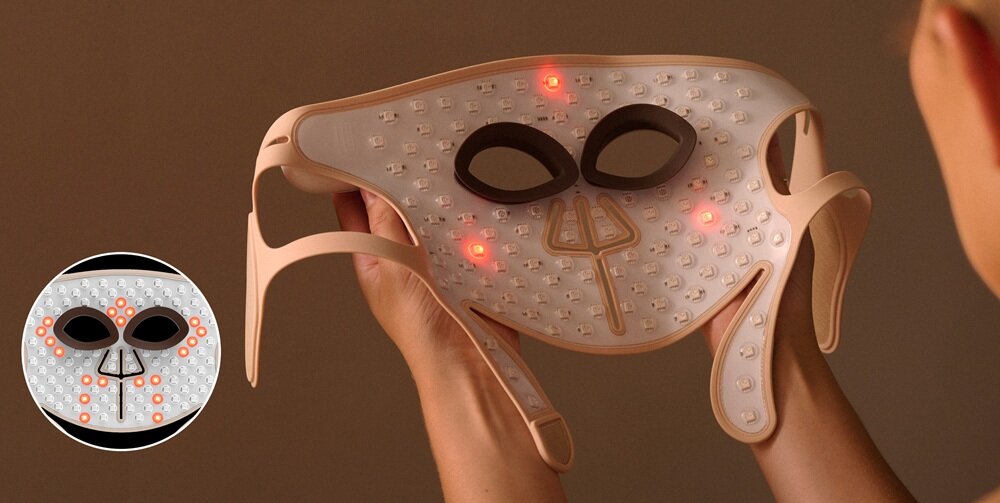 Osoba trzyma maskę LED do twarzy z widocznymi czerwonymi diodami i otworami na oczy. W lewym dolnym rogu znajduje się zbliżenie maski z włączonymi diodami.