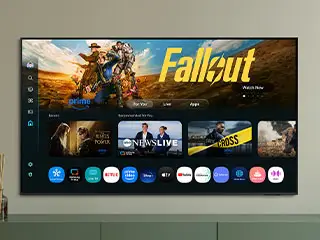 320x240-one-ui-tizen eu-v2 Telewizor wyświetla ekran główny z aplikacjami i reklamą gry \'Fallout\'. Widoczne są ikony aplikacji takich jak Prime Video, Netflix, i YouTube.